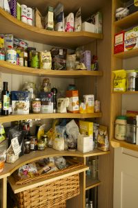 Full height bespoke larder cupboard with oak shelving and spice racks
