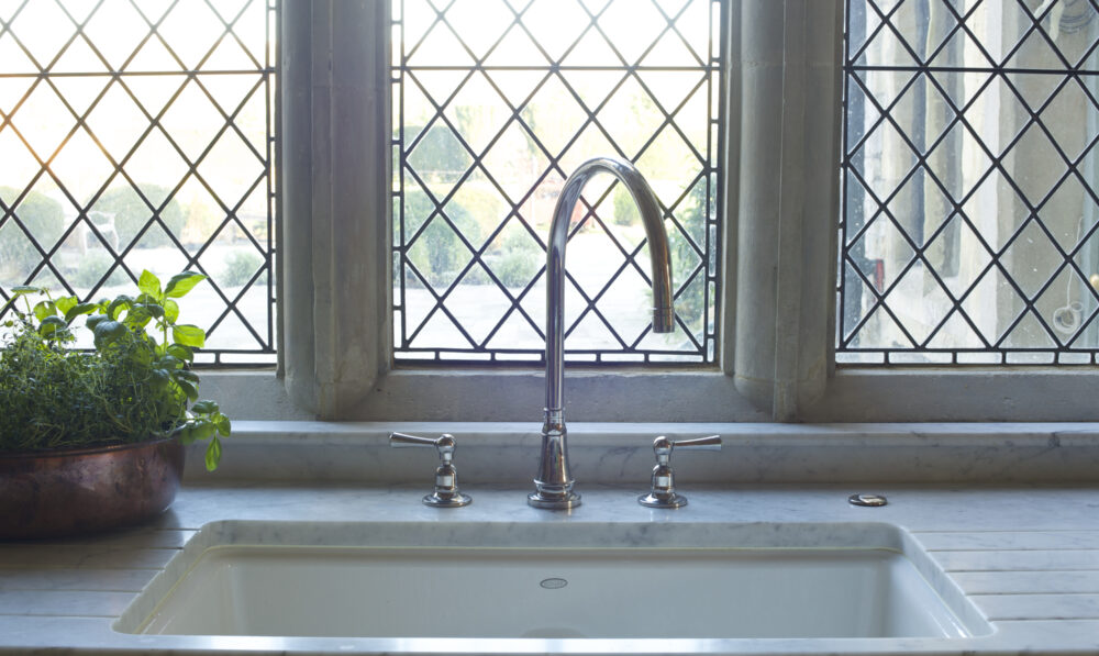 An enamel sink in a mullioned country house window