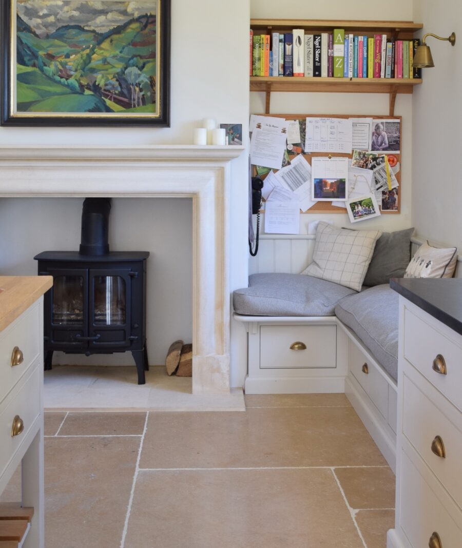 Log burning stove positioned at one end of a bespoke kitchen
