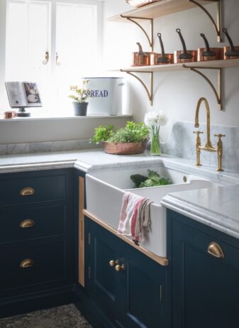 A modern scullery benefits from open shelves, bespoke cabinetry, Butler's sink and stone worktops  