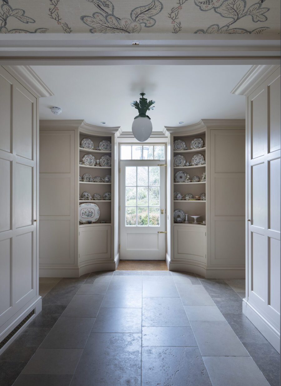 The china display cabinets sit either side of an external door in a panelled lobby The china display cabinets sit either side of an external door in a panelled lobby