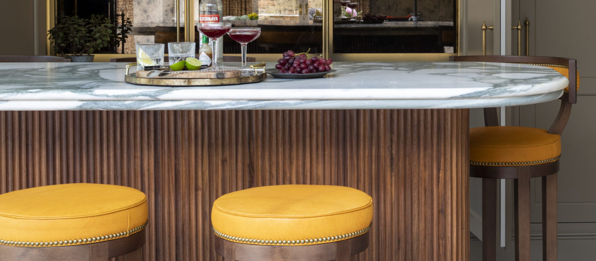 A bespoke fluted American walnut cocktail bar with marble worktop