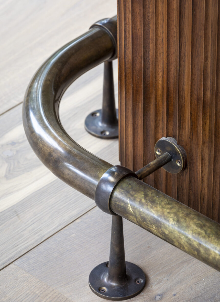 An antiques brass foot rail runs around the bottom of the bespoke cocktail bar An antiques brass foot rail runs around the bottom of the bespoke cocktail bar
