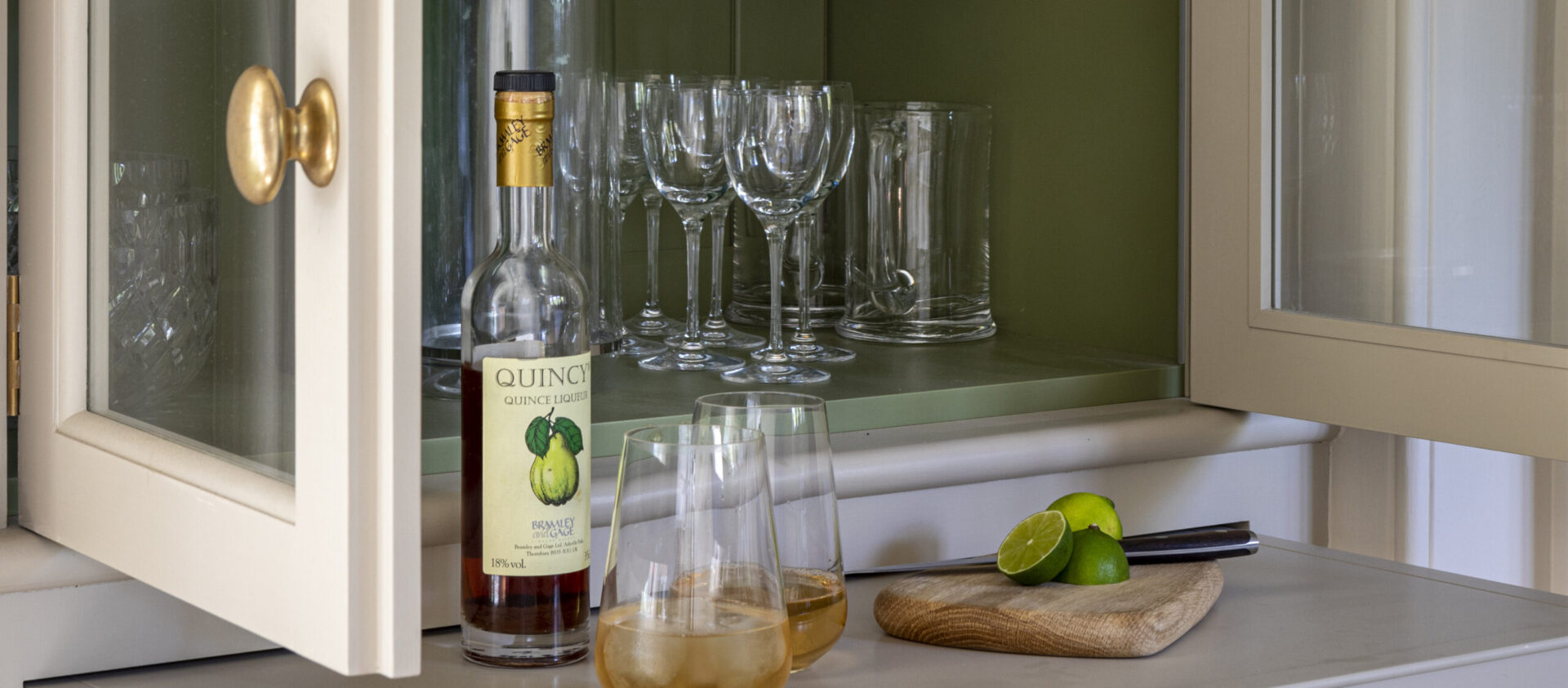 Hand painted green glazed drinks cabinet in a Georgian country house kitchen