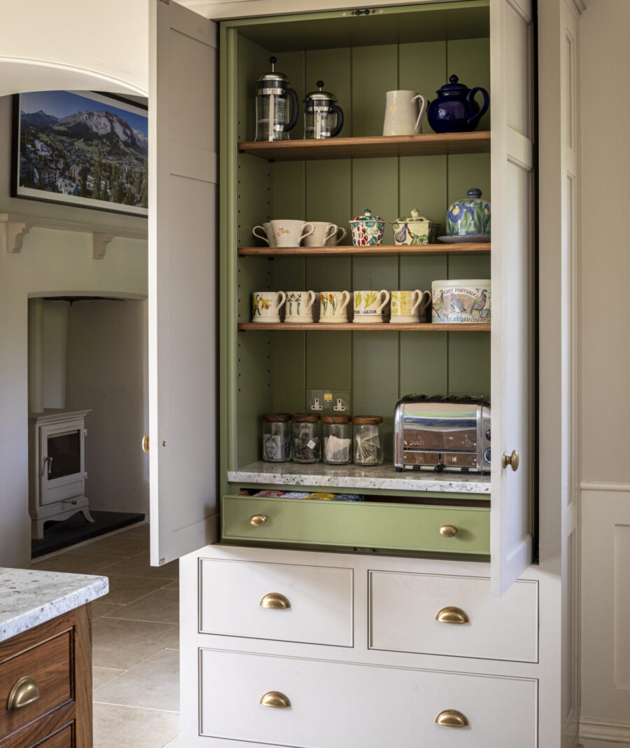 Log burner sits comfortably at one end of this bespoke kitchen