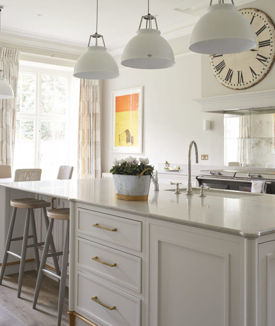 Three large pendant lights sit above a bespoke kitchen island Three large pendant lights sit above a bespoke kitchen island