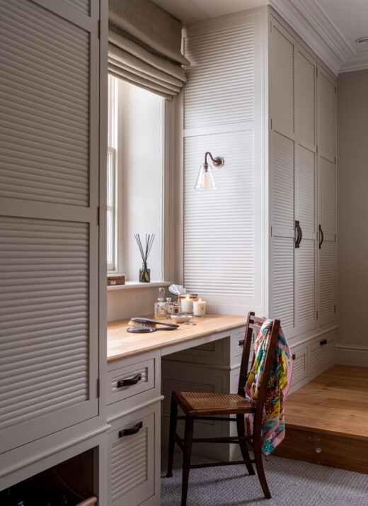 Some paintd wardrobes with a vanity table in between them 