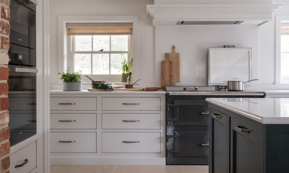 Neutral cabinetry with pale worktops and oak shelves