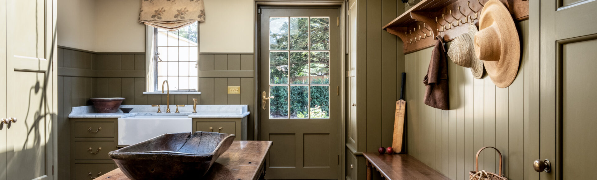 A bespoke bootroom design in a Wiltshire country house in olive green