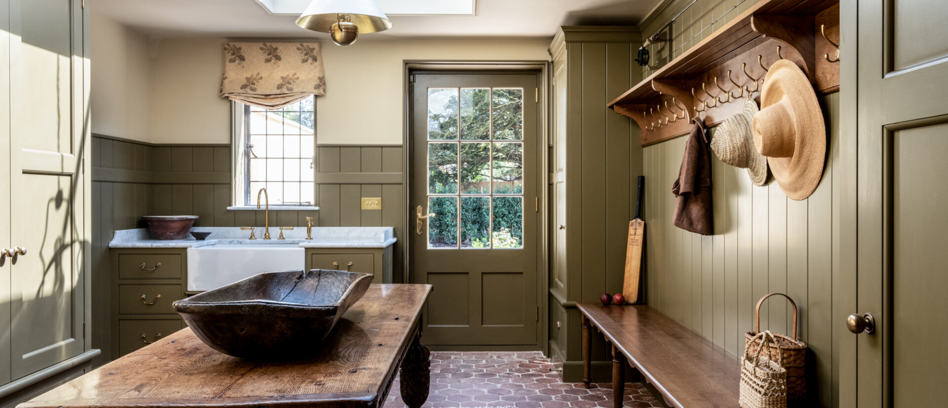 A bespoke bootroom design in a Wiltshire country house in olive green
