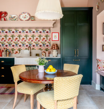 A small dining table creates a relaxed dining area in the window of this bespoke kitchen