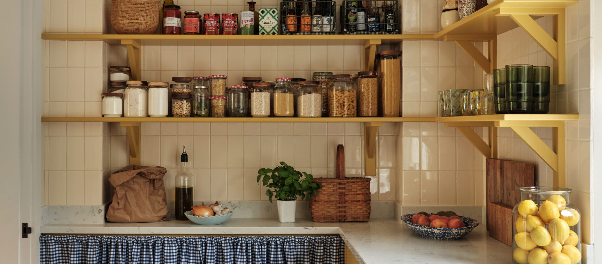 A walk-in kitchen pantry with a large combination of storage options on shelves