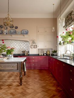 Red kitchen in Northumberland with black marble worktops