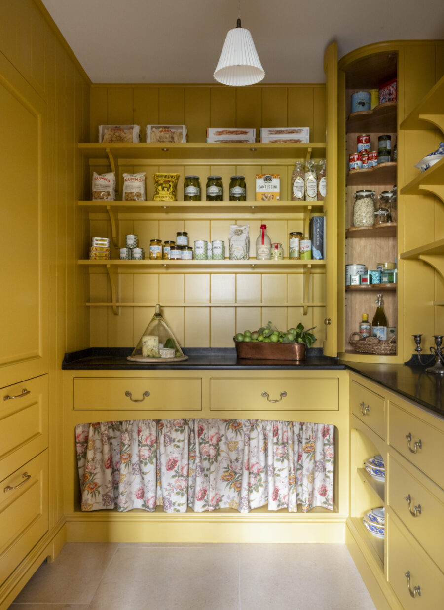 Yellow walk-in kitchen pantry with curved corner cabinet