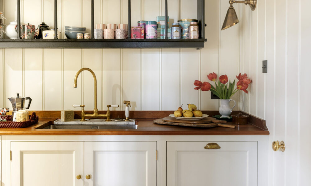 a white panelled pantry with iroko worktops