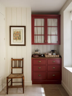 a panelled pantry with red glazed wall cabinet and drawers