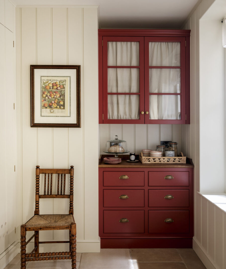 a panelled pantry with red glazed wall cabinet and drawers
