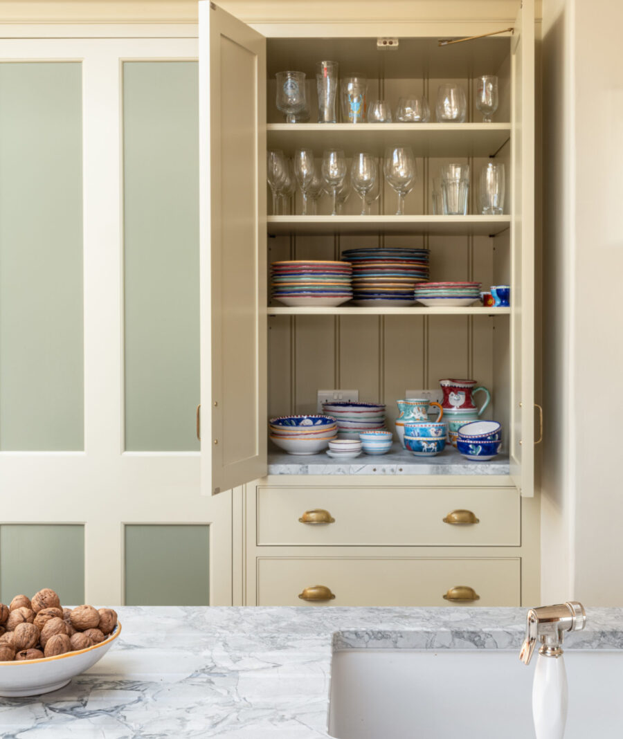 Bespoke cabinetry design for a Somerset country farmhouse with pocket doors hiding a larder cabinet
