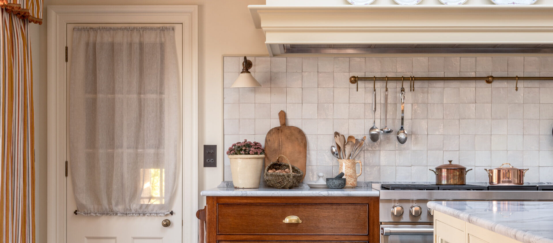 A Country Farmhouse Kitchen with oak drawers and glazed kitchen door with curtain near Wedmore, Somerset