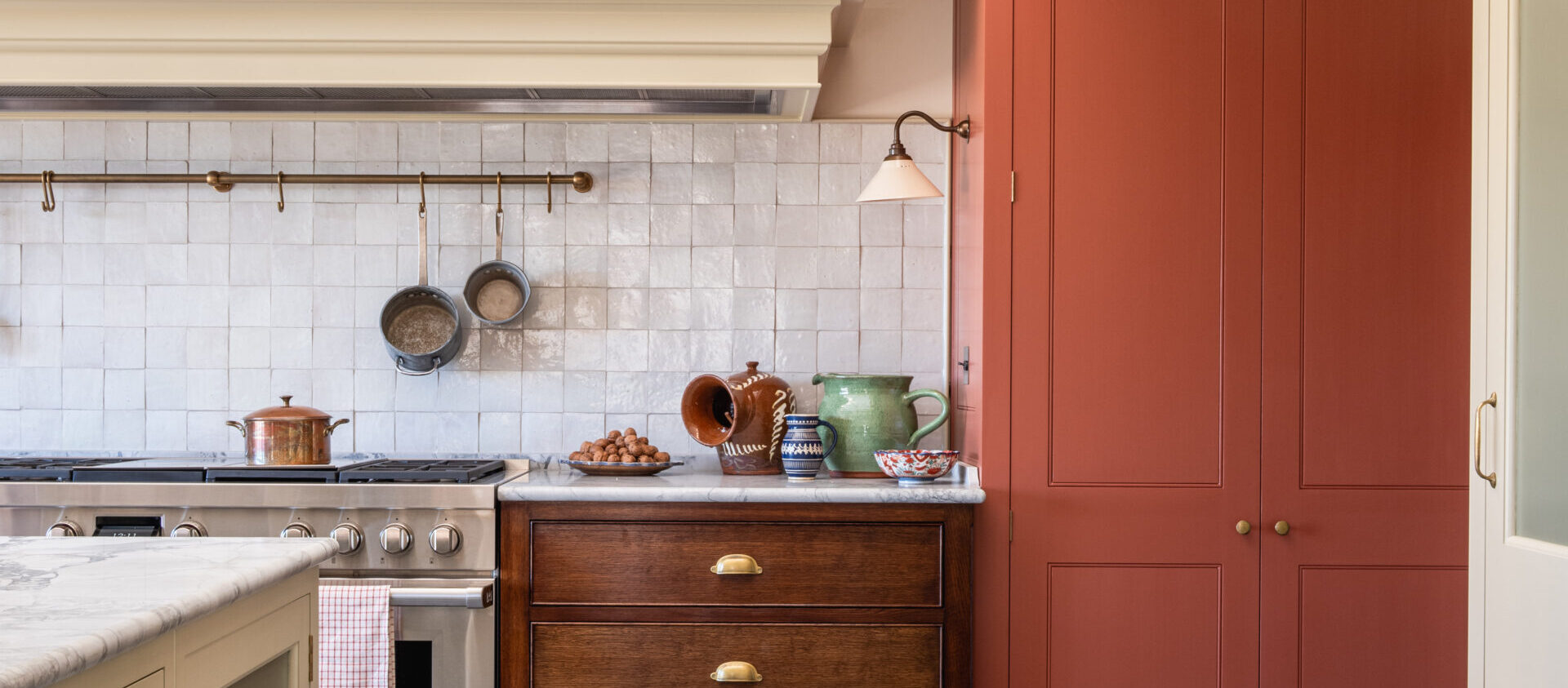 Oak drawers, pale hand-painted cabinetry and a contrasting tall red larder cabinet in a bespoke kitchen near Devon