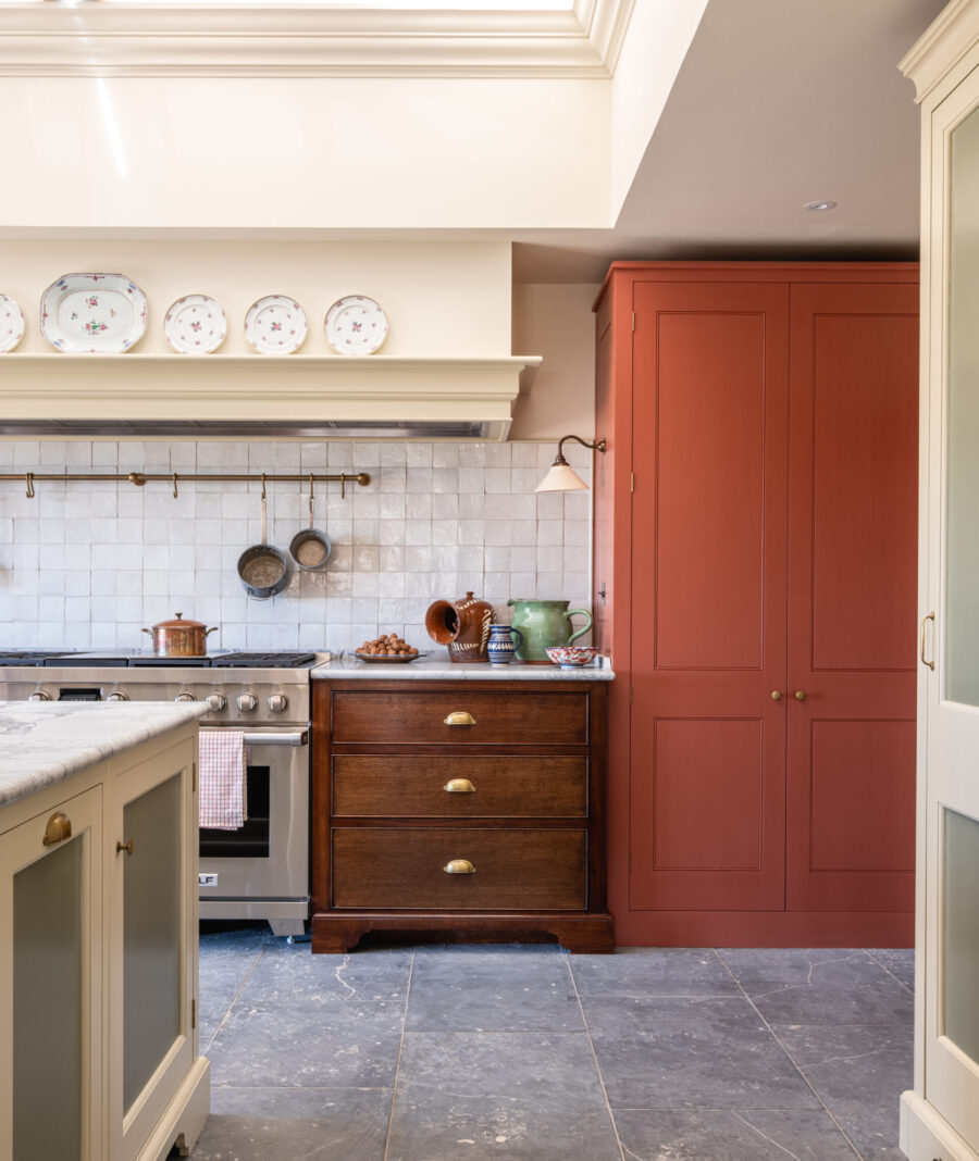Oak drawers, pale hand-painted cabinetry and a contrasting tall red larder cabinet