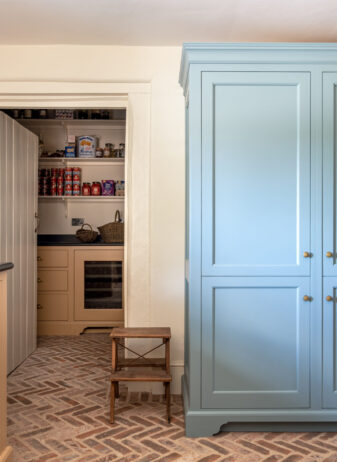 Farmhouse Kitchen Scullery with blue Housekeeper's cabinet hiding a fridge/freezer