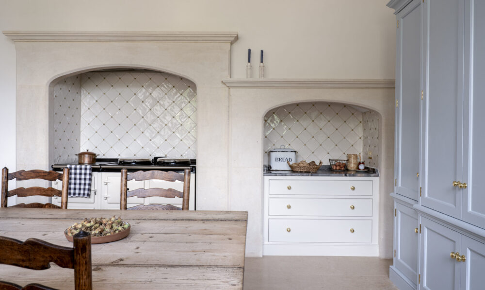 A housekeeper's cupboard with an Aga in a stone chimney 