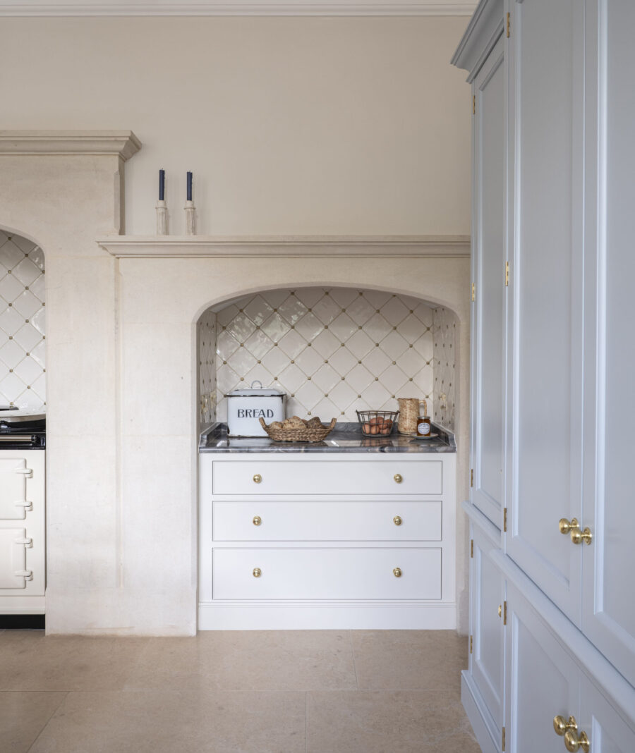 Bespoke cabinetry design with two stone mantels with chest of drawers, and a large pale blue Housekeeper's cabinet
