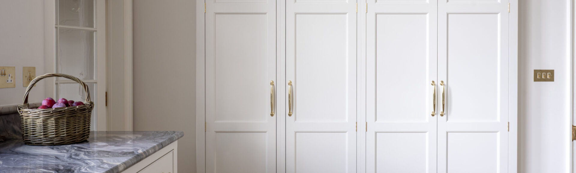 A large storage cupboard recessed into the wall in a kitchen