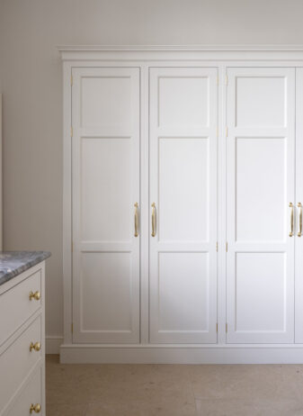 A large storage cupboard recessed into the wall in a kitchen