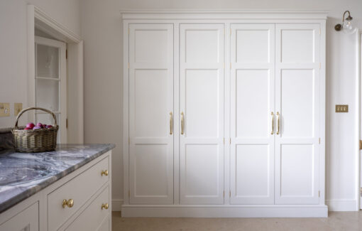 A large storage cupboard recessed into the wall in a kitchen
