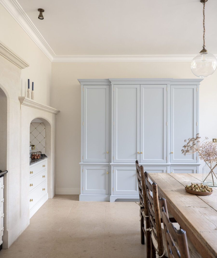 A pale blue housekeeper's cupboard sits at the end of the room in a Kitchen for a Regency Villa