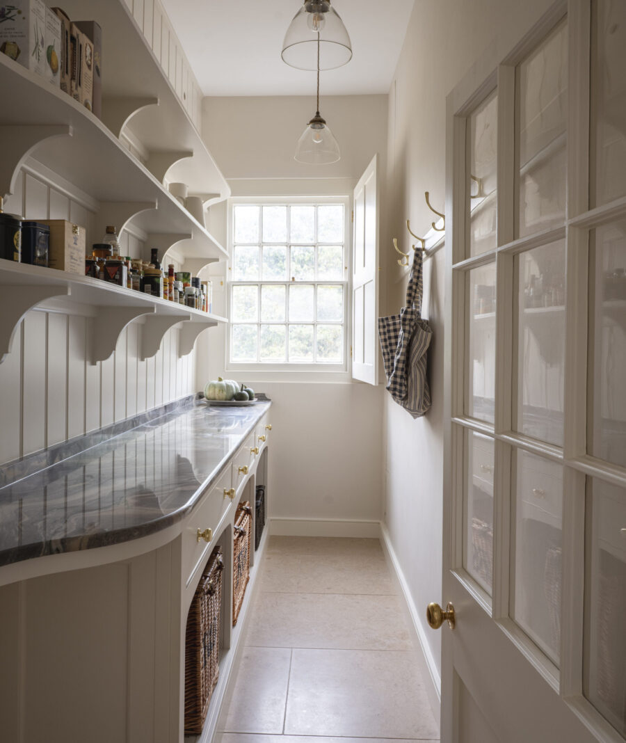 Pantry shelving stocked with ingredients with glazed door and window beyond Pantry shelving stocked with ingredients with glazed door and window beyond