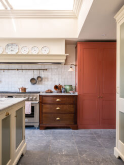 A Country Farmhouse Kitchen with oak drawers and tall red larder cabinet
