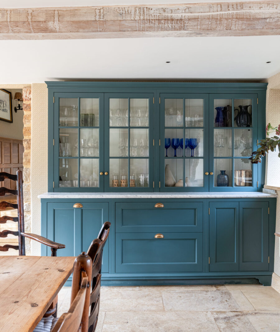 A blue hand painted bespoke kitchen dresser in a Dorset Manor house with glazed cabinets above drawers