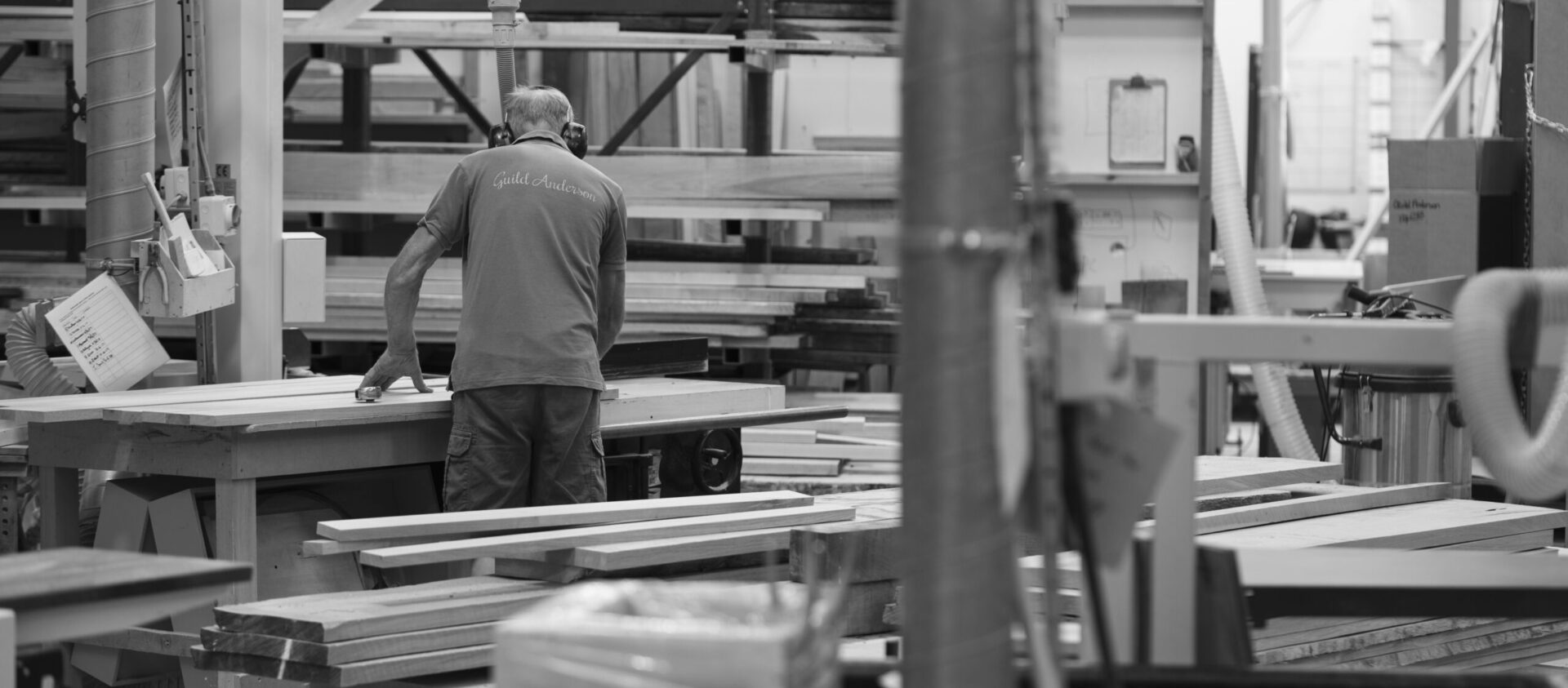 Guild Anderson workshop team member surrounded by a selection of wood