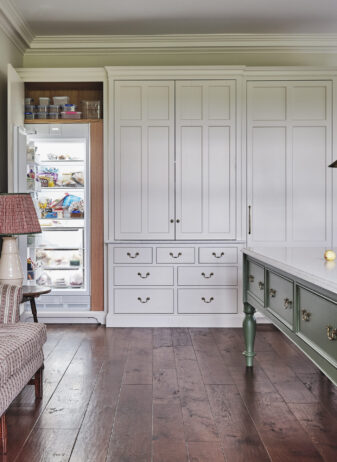 Classically proportioned hand painted cabinetry houses a hidden fridge Classically proportioned hand painted cabinetry houses a hidden fridge