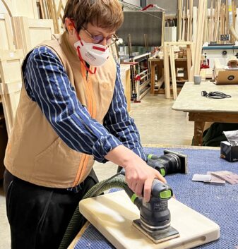 A student working on their wooden chopping board in the Guild Anderson workshop
